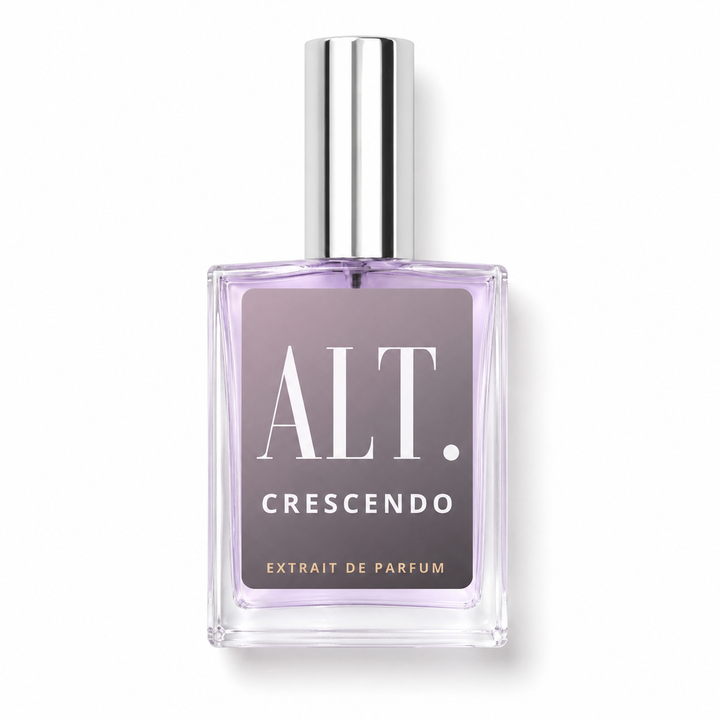 A rectangular glass perfume bottle with a silver cap, containing light purple liquid. The front features a dark purple label with white text reading &