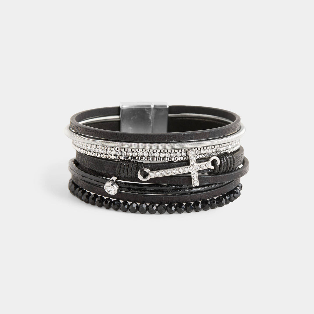 Stack of black and silver bracelets on a light gray background