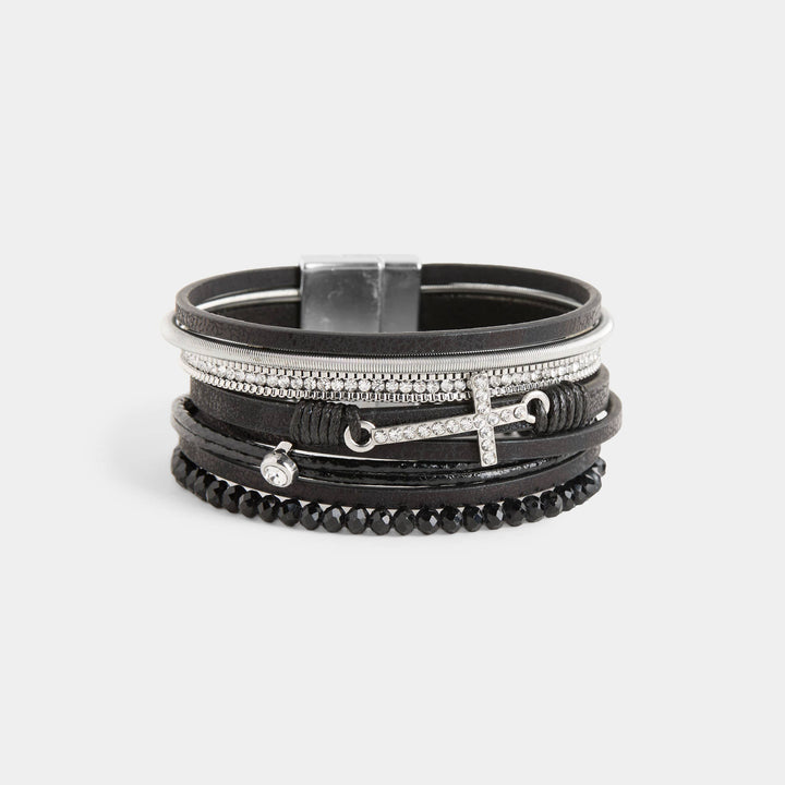 Stack of black and silver bracelets on a light gray background