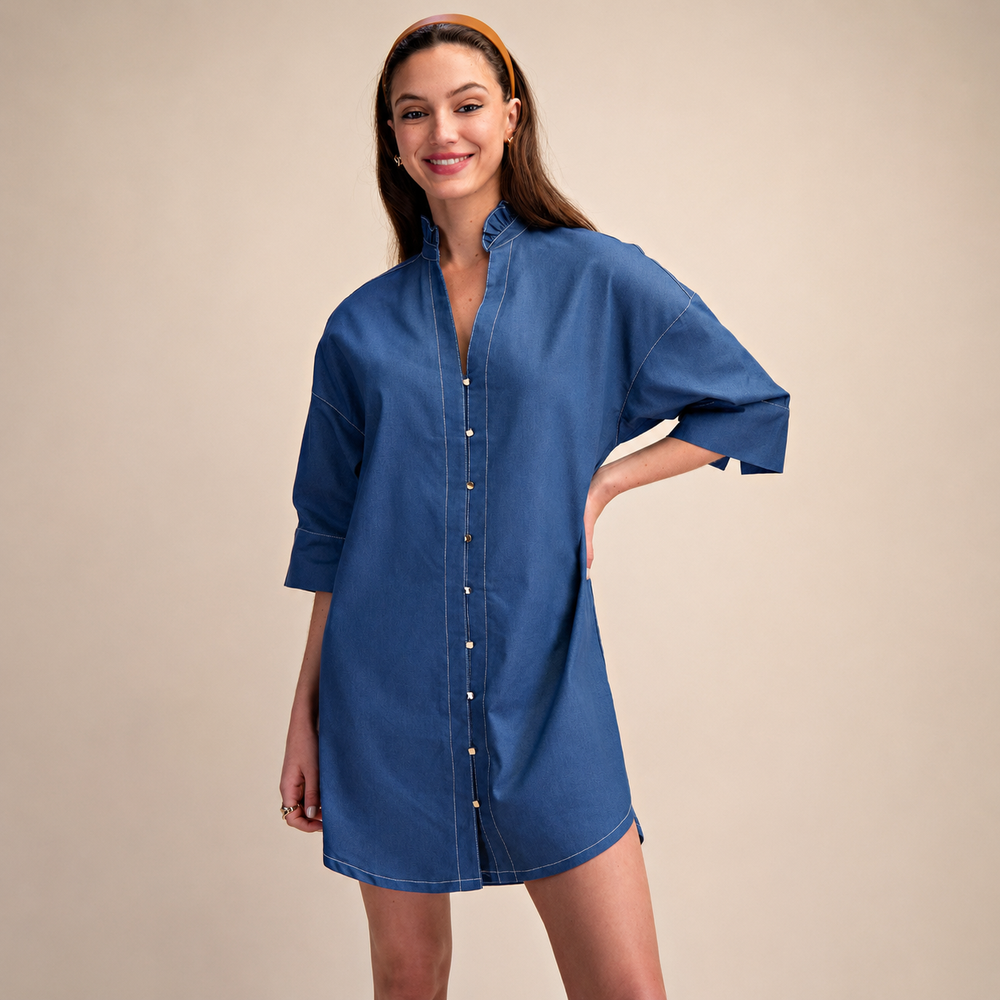 Woman wearing a blue shirt dress against a beige background