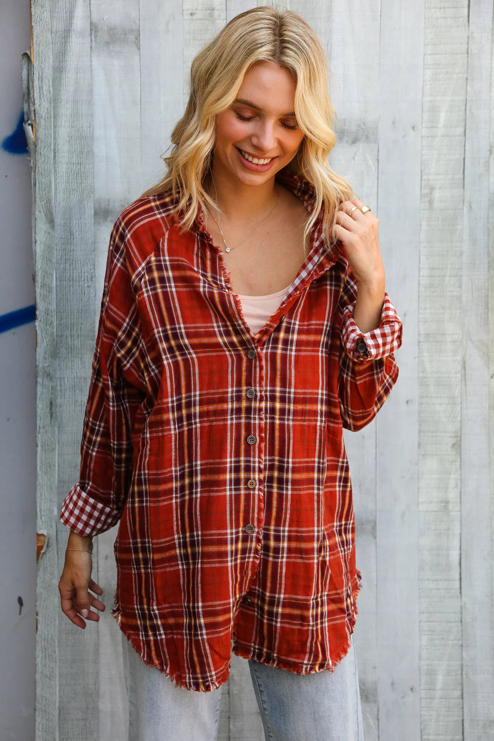 Woman wearing a red plaid shirt against a wooden background
