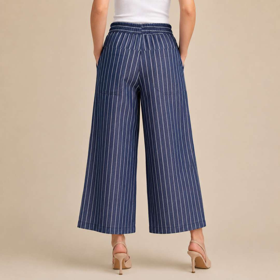 Woman wearing blue pinstripe pants on a beige background