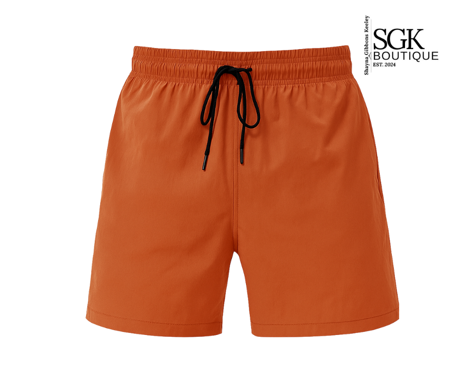 Orange shorts with a black drawstring on a white background, featuring the SGK Boutique logo.