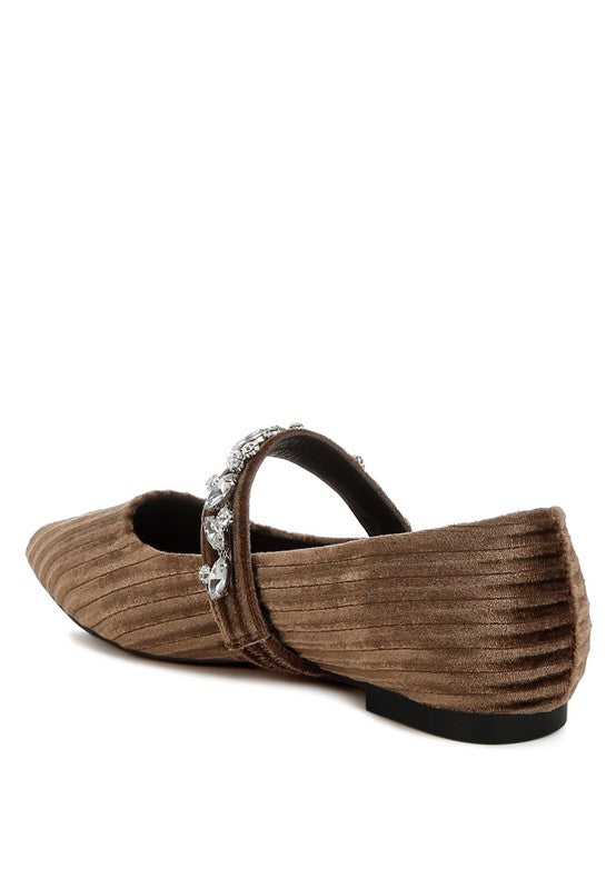 Brown flat shoe with a decorative strap on a white background