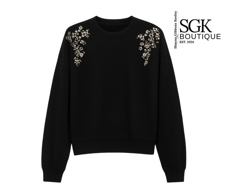 Black sweatshirt with floral embellishments on shoulders by SGK Boutique.