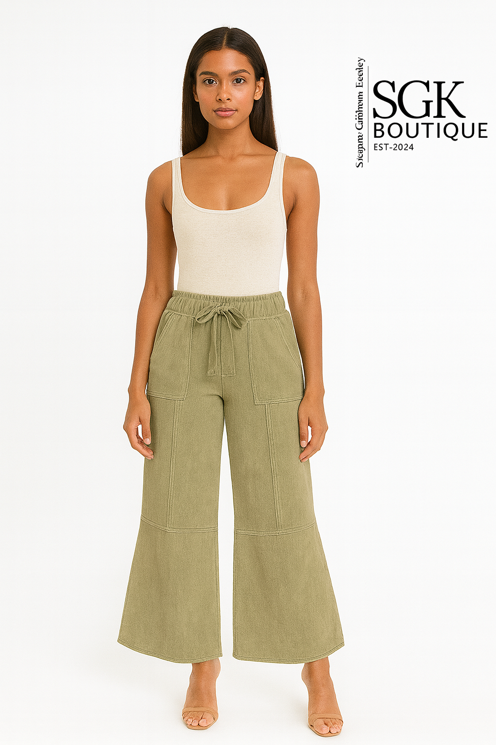 Woman wearing a white tank top and green wide-leg pants on a white background with SGK Boutique branding.