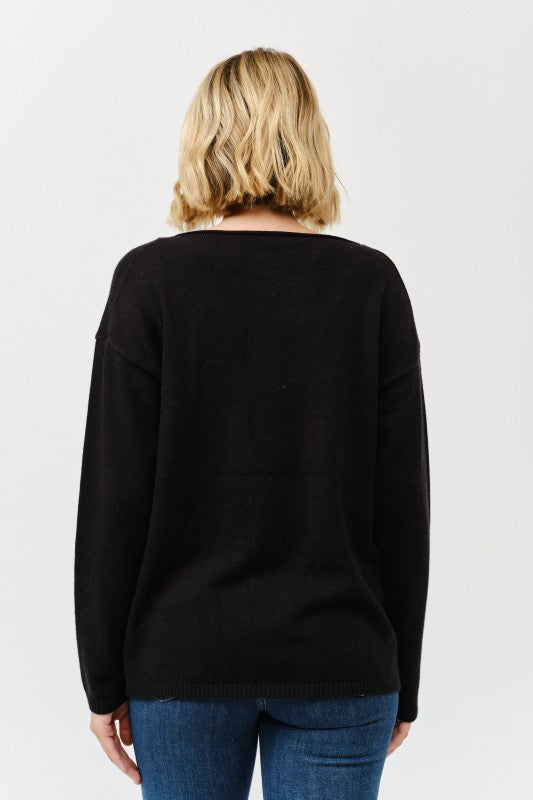 Person wearing a black sweater and blue jeans on a white background