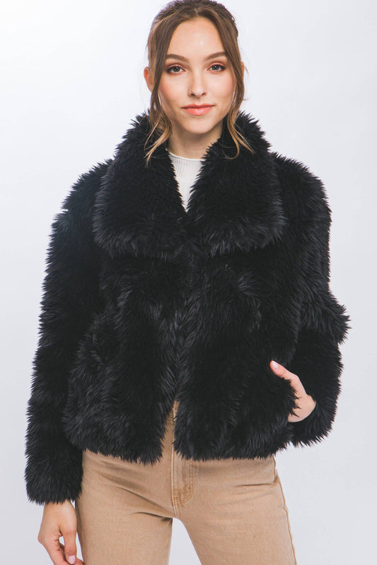 Woman wearing a black fur coat against a white background