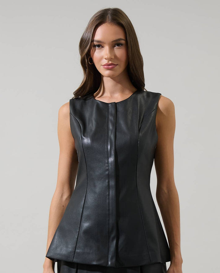 Woman wearing a black leather dress against a gray background