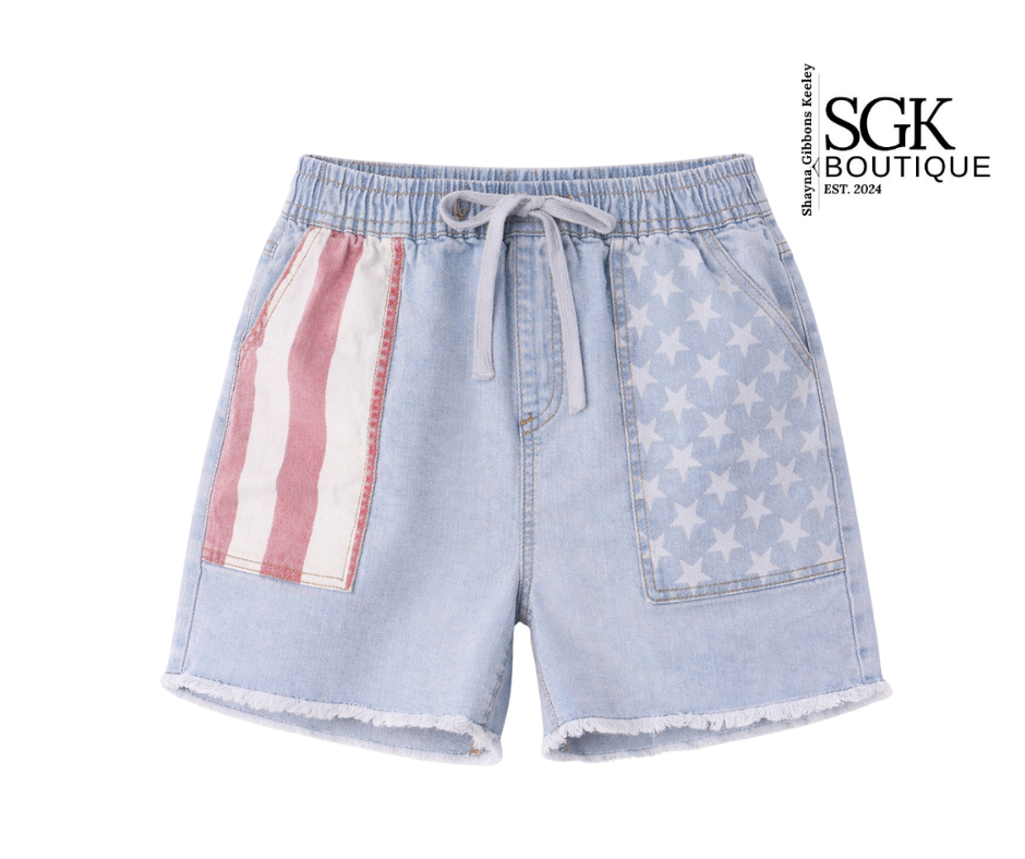 Denim shorts with American flag patch and star pattern on a white background, branded as SGK Boutique.