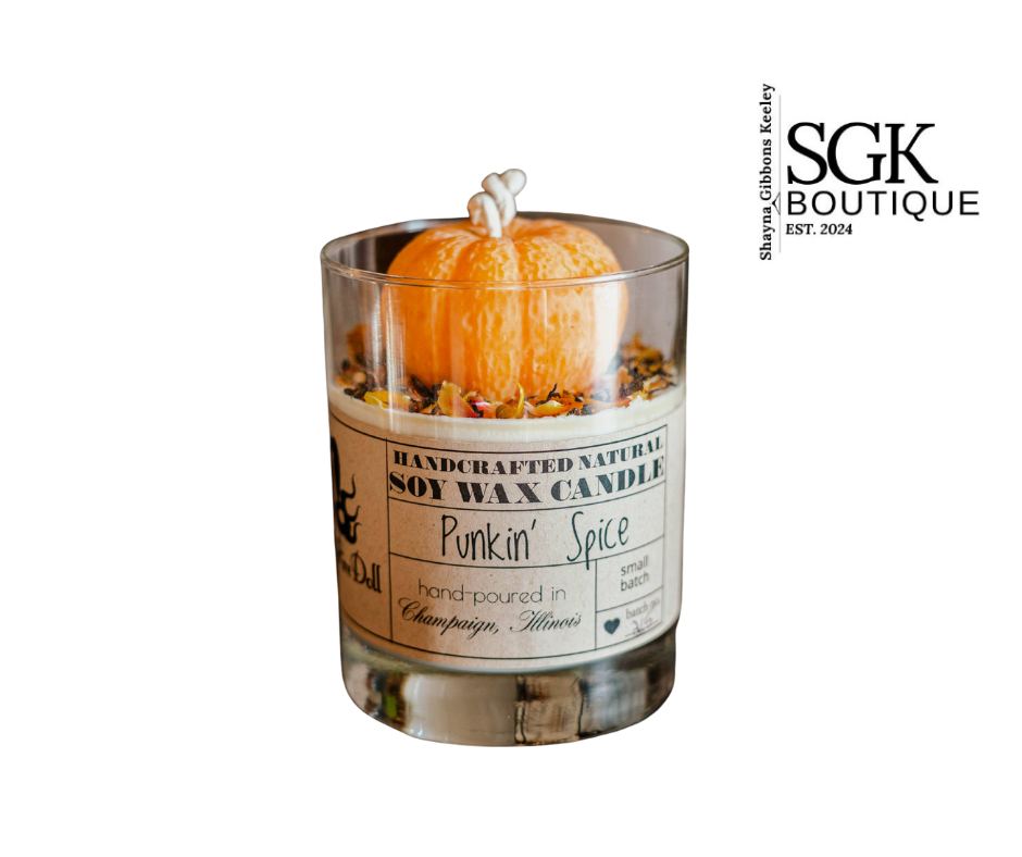 Pumpkin spice candle in a glass container with a decorative label, featuring SGK Boutique branding.
