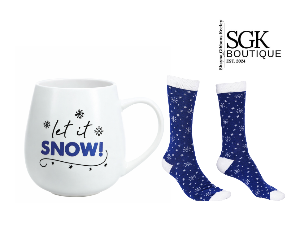 White mug with 'let it snow!' text and two pairs of blue socks with white patterns on a white background.