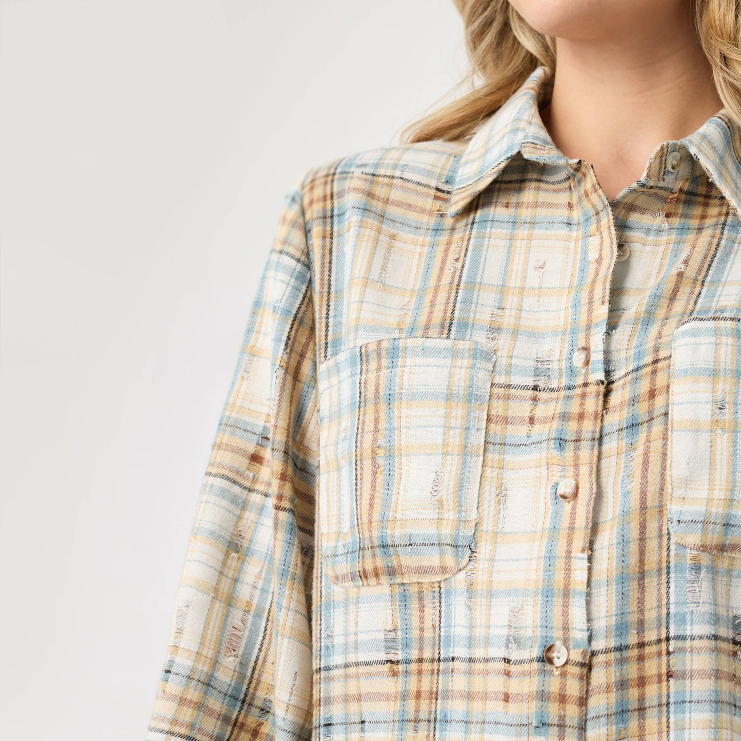 Plaid shirt worn by a person on a light gray background