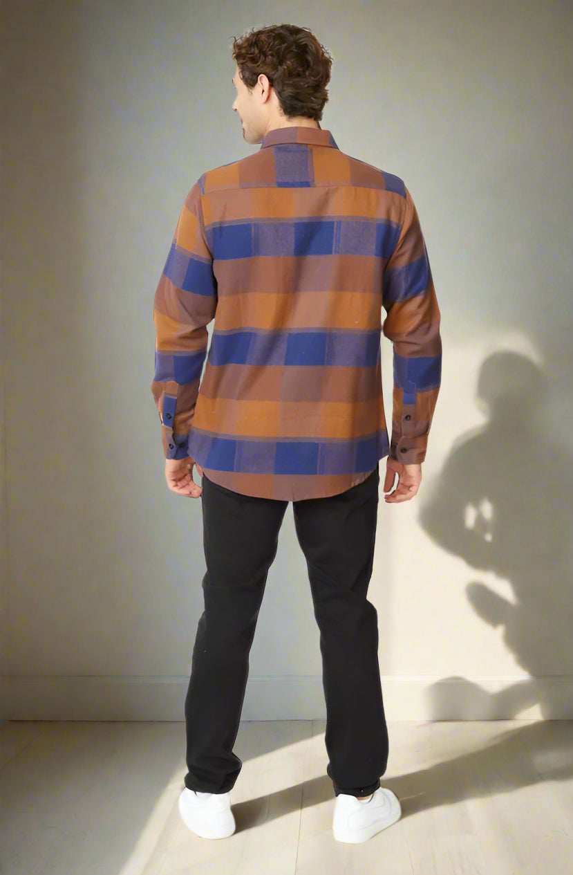 Person wearing a plaid shirt and black pants on a white background