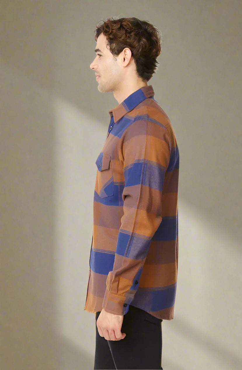 Man wearing a brown and blue plaid shirt on a white background