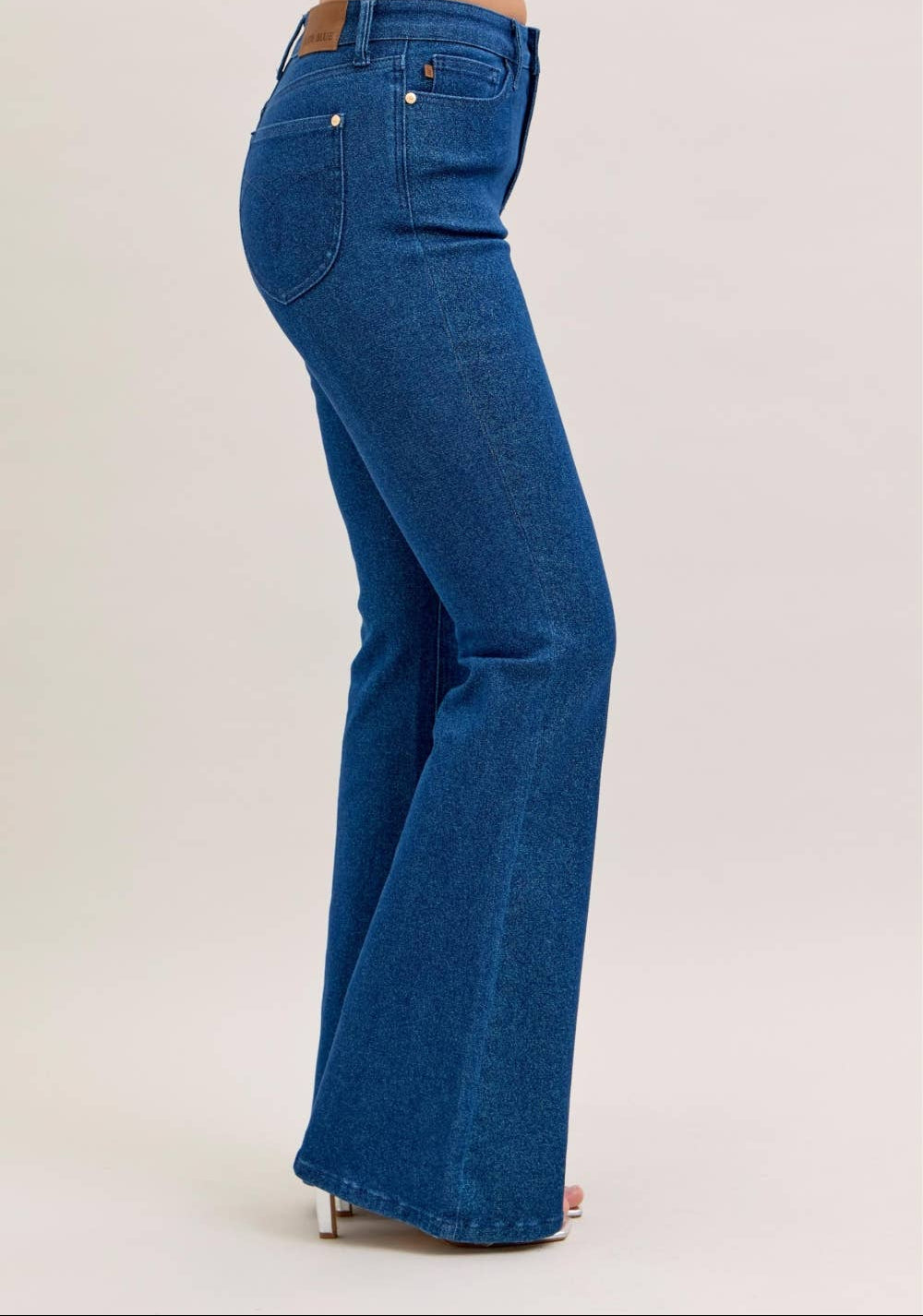 Blue jeans worn by a person on a light beige background