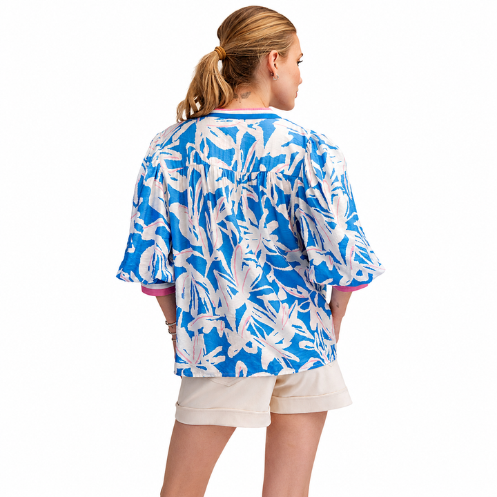 Woman wearing a blue and white floral kimono-style top on a white background