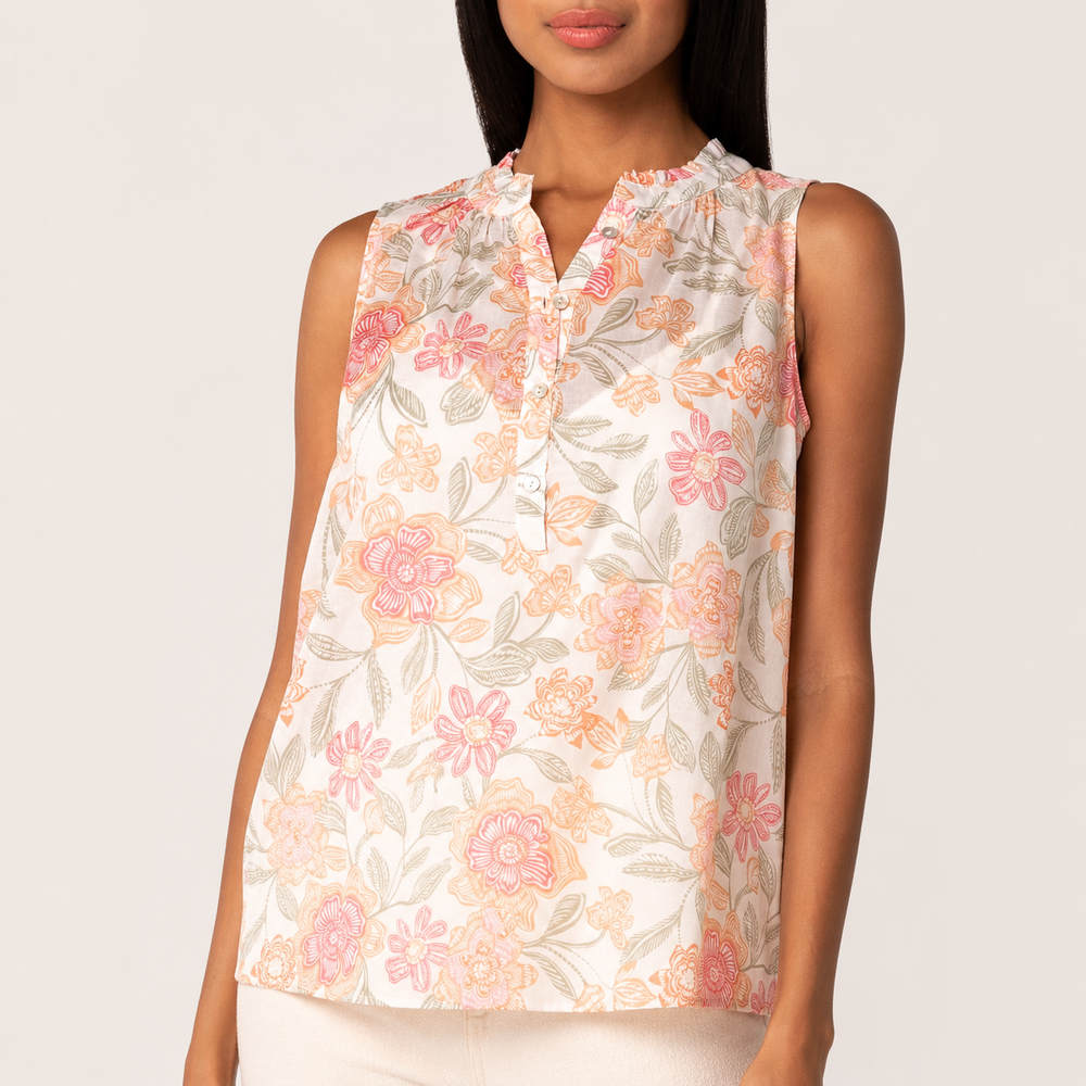 Woman wearing a sleeveless floral top on a plain background