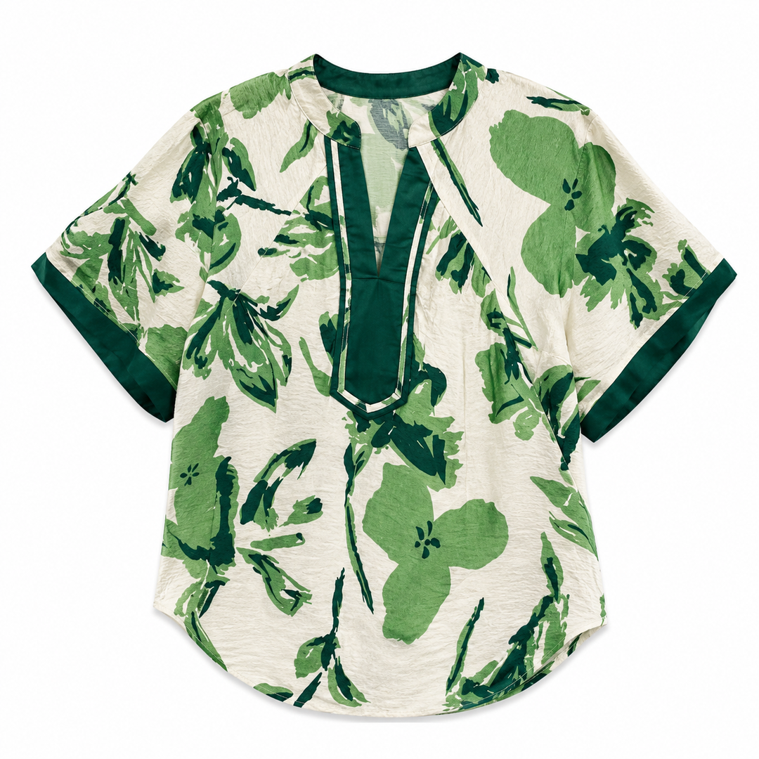 A short-sleeve blouse with a green floral and leaf print on an off-white background, featuring a dark green split neckline and sleeve trim.