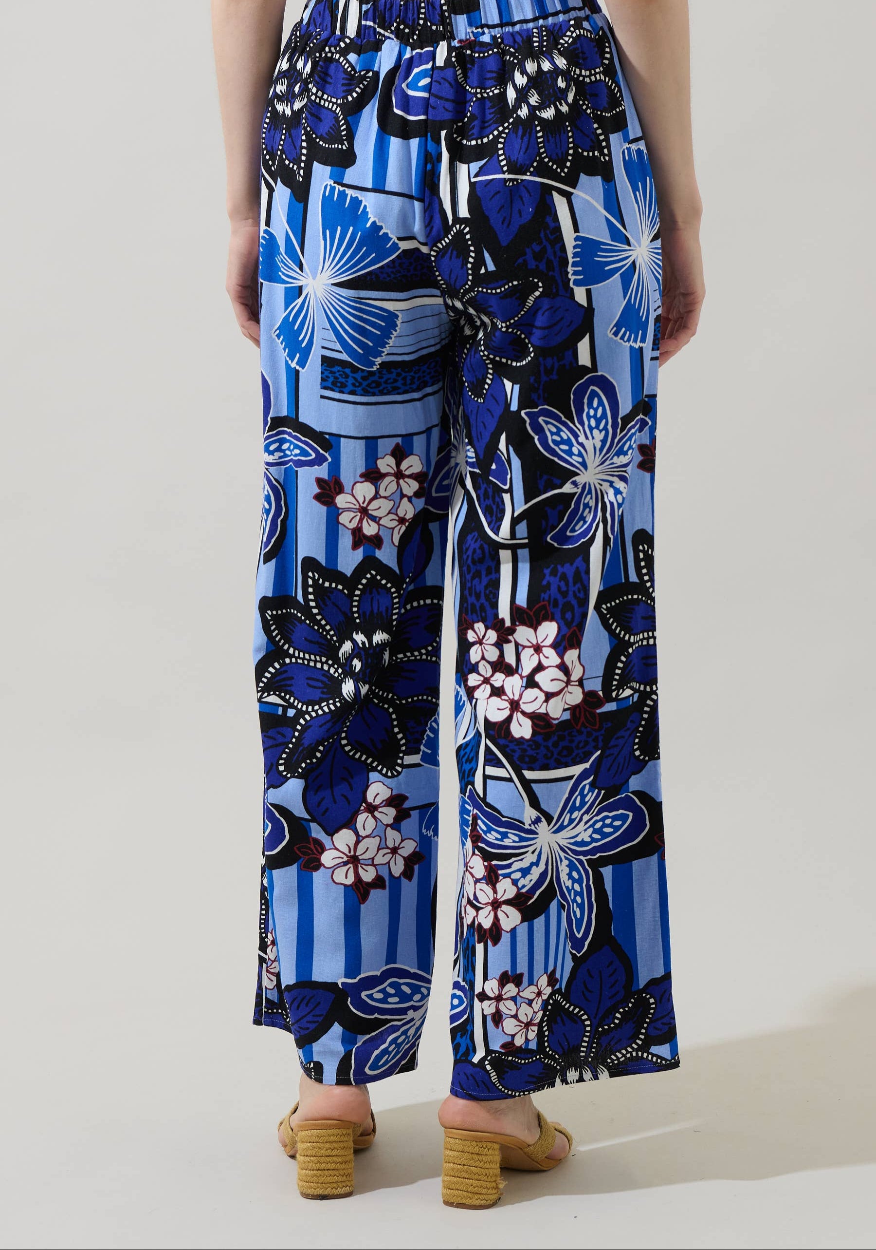 Blue floral patterned pants worn by a person on a light background