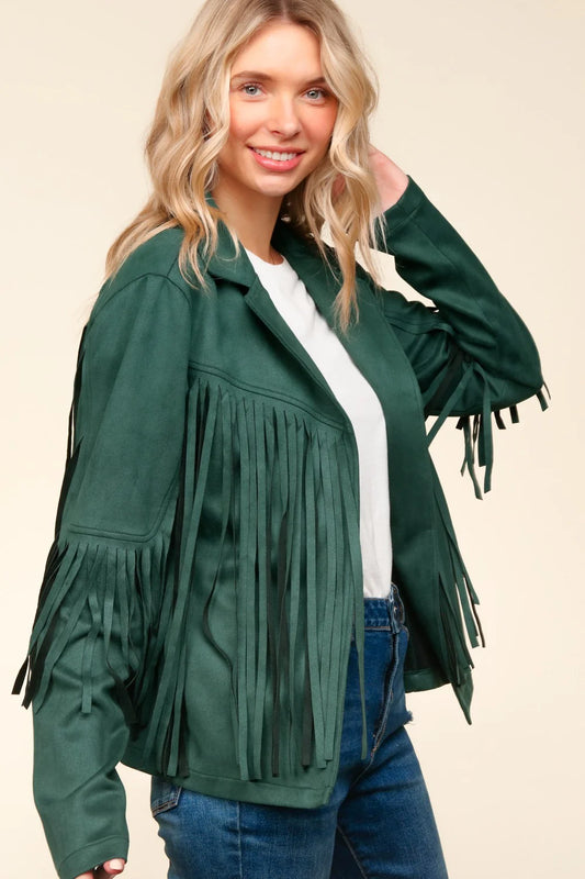 Woman wearing a green fringed jacket on a beige background