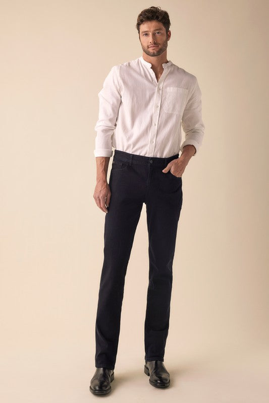 Man wearing a white dress shirt and dark pants on a beige background