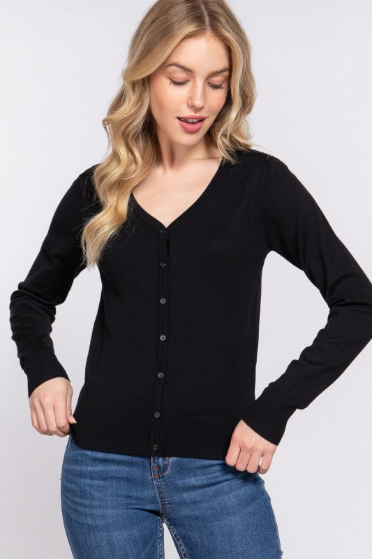Woman wearing a black cardigan and blue jeans on a white background
