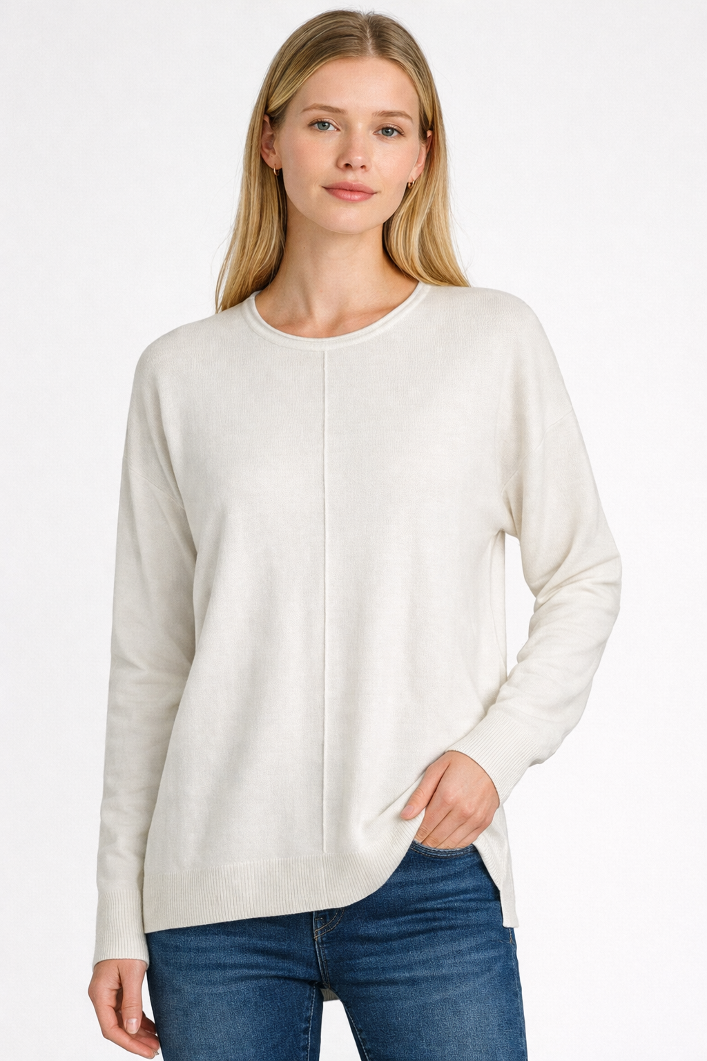 Woman wearing a white sweater and blue jeans on a white background