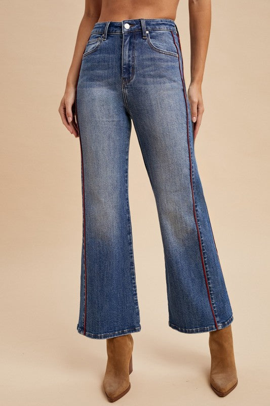 Blue jeans worn by a person on a beige background