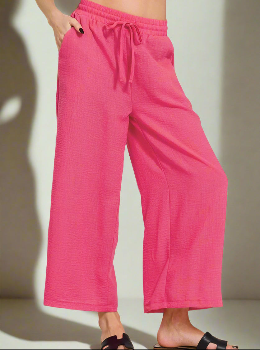 Pink wide-leg pants worn by a person on a neutral background