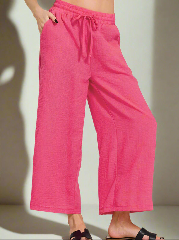 Pink wide-leg pants worn by a person on a neutral background