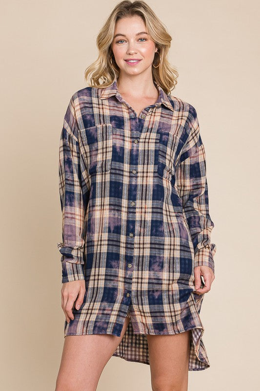Woman wearing a plaid shirt dress against a beige background