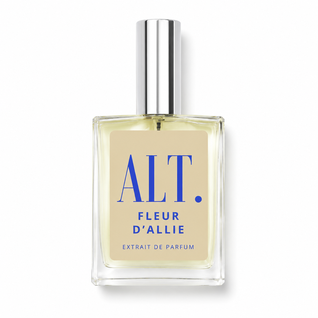 A rectangular glass perfume bottle with a silver cap, featuring a beige label with blue text that reads &