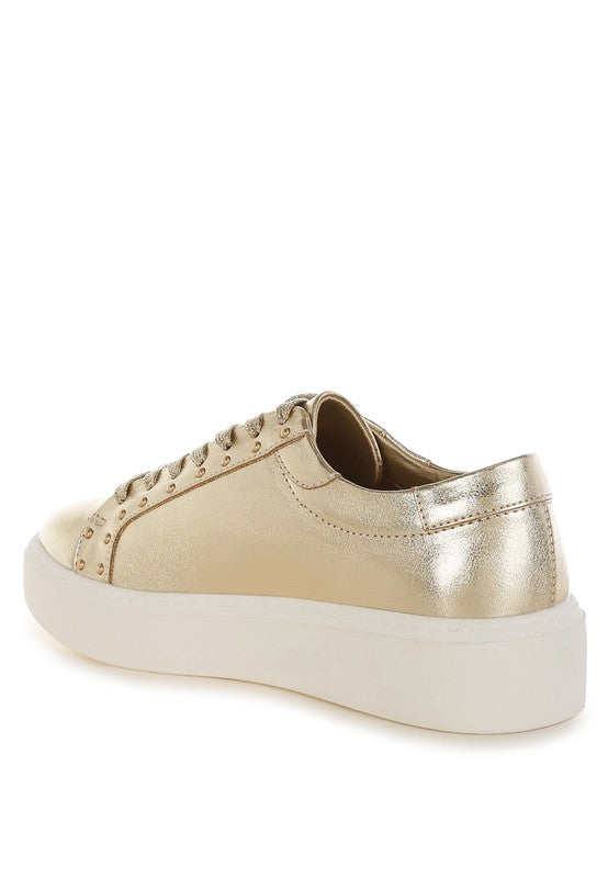 Gold sneaker with white sole on a white background