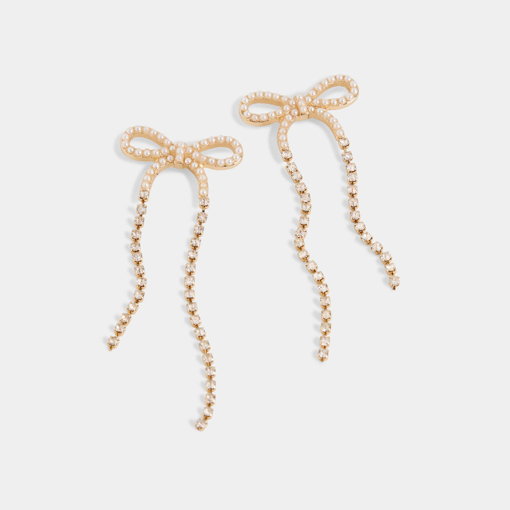 Pair of pearl bow earrings on a light gray background