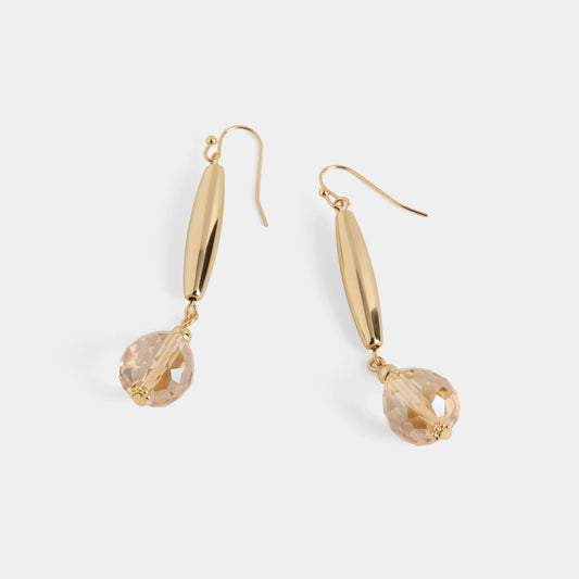 Gold earrings with clear gemstones on a light gray background
