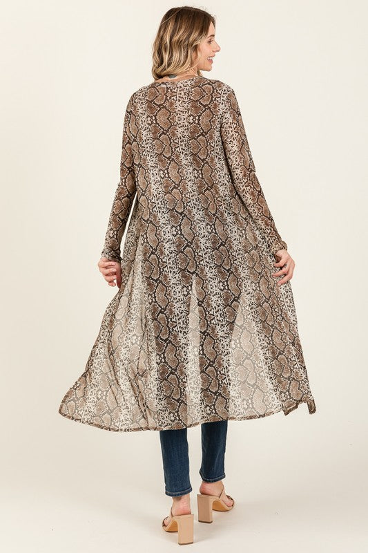 Woman wearing a long, patterned lace dress on a plain background