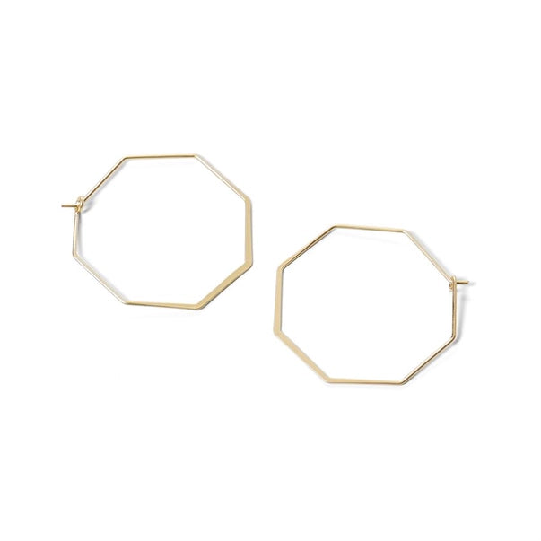 Hexagonal gold hoop earrings on a white background