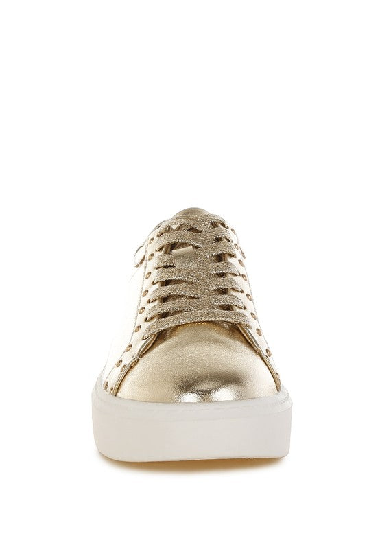 Gold sneaker with white sole on a white background