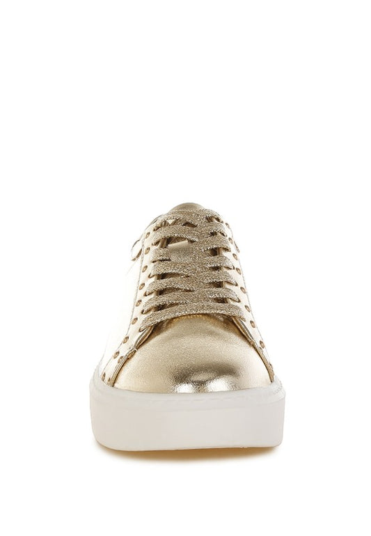 Gold sneaker with white sole on a white background