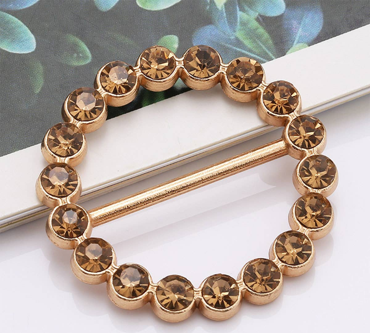 Gold bracelet with brown gemstones on a white surface