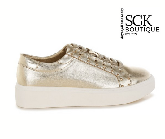 Gold sneaker with studded details on a white background, featuring SGK Boutique logo.