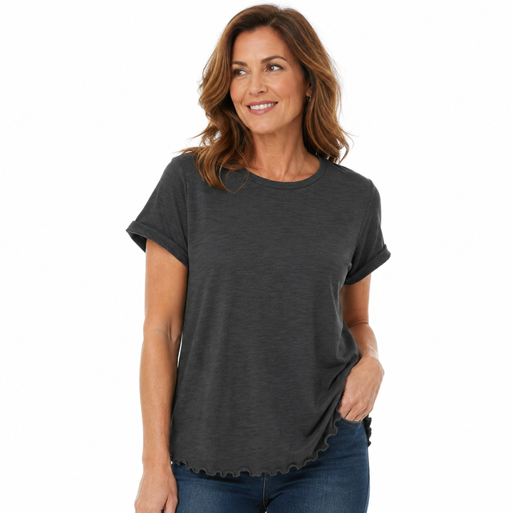 A woman wearing a dark charcoal gray short-sleeve t-shirt with a scalloped hem, paired with blue jeans, against a plain white background.