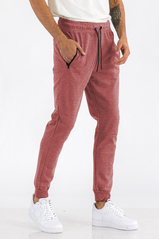 Person wearing pink jogger pants and white sneakers on a white background