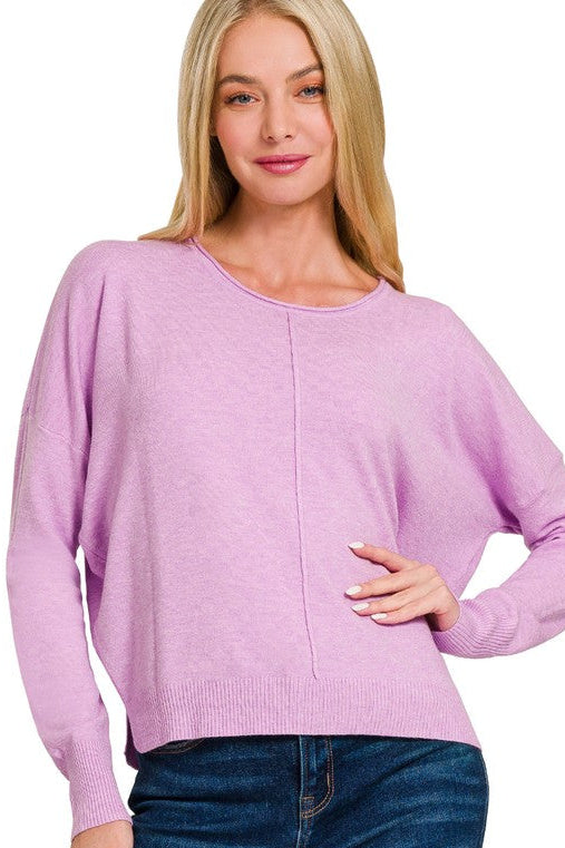 Woman wearing a heather mauve sweater with a plain background