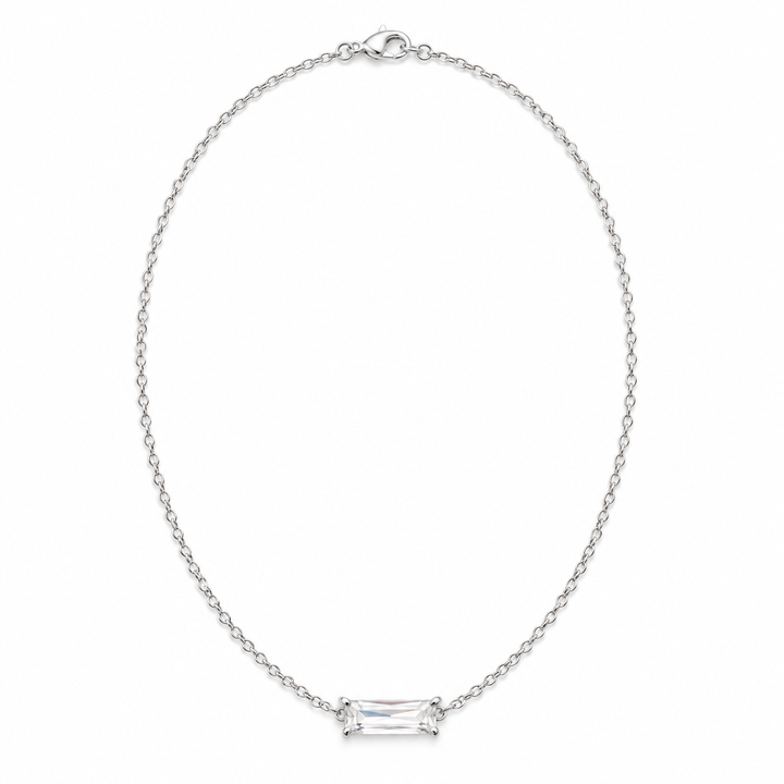 A silver chain necklace with a rectangular baguette-cut clear gemstone set in a four-prong setting, displayed on a clean white background.