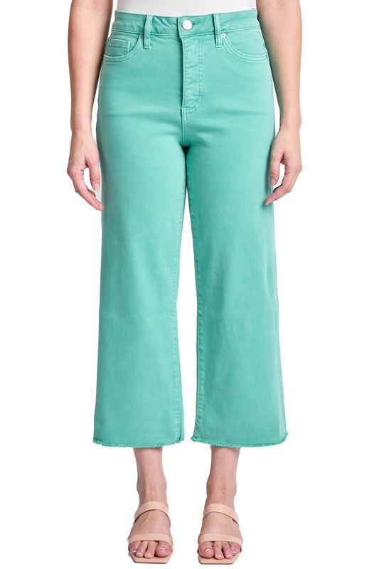 Person wearing teal pants on a white background