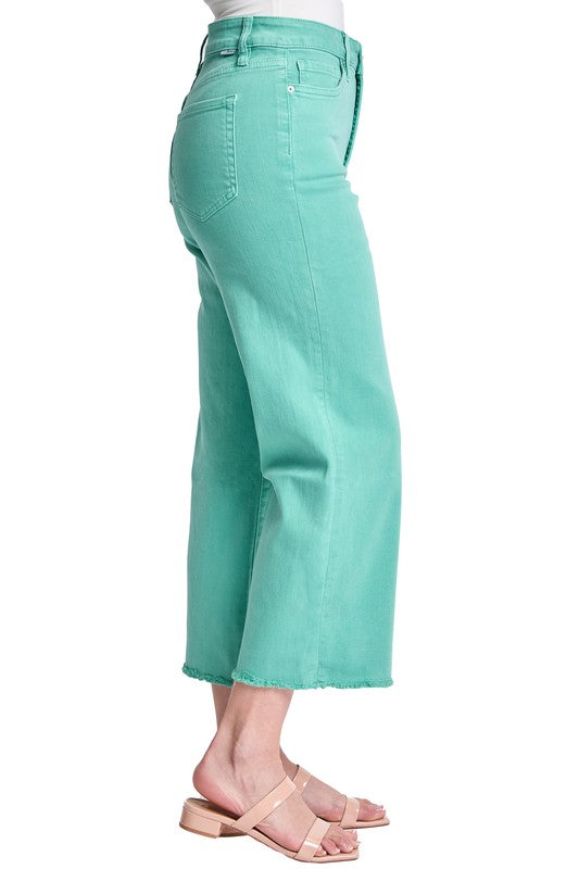 Teal jeans worn by a person on a white background
