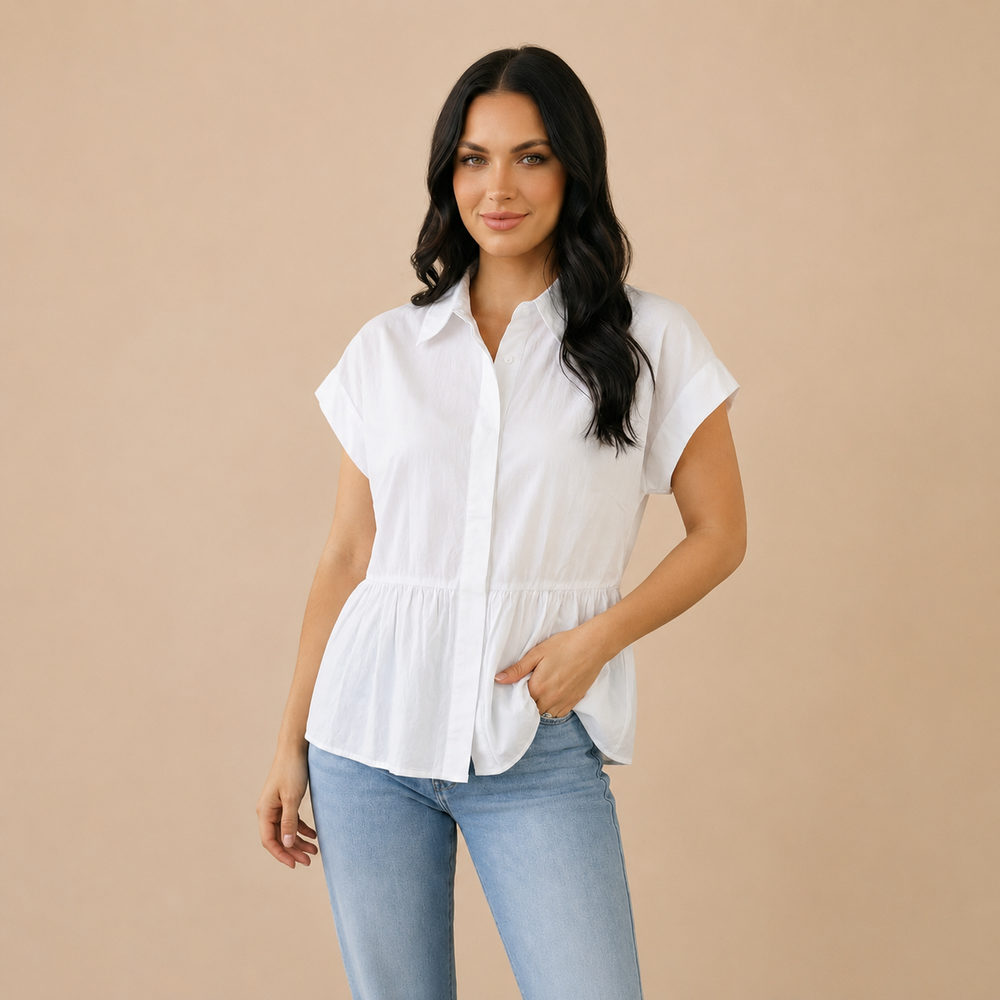 Woman wearing a white blouse and blue jeans against a beige background