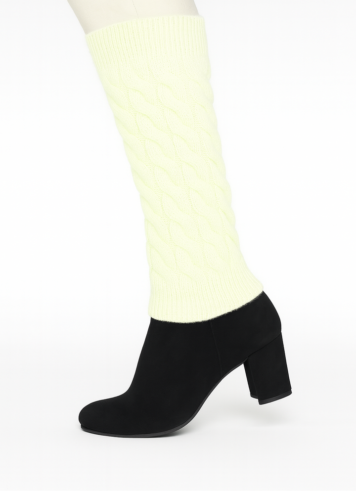 Black ankle boots worn with white tights on a white background